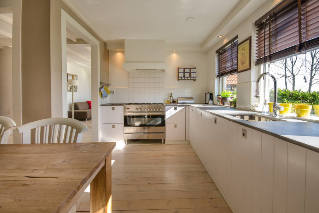 A bright and spotless kitchen showcasing the results of effective cleaning tips for busy homeowners, with natural light, white cabinets, and an organized space.